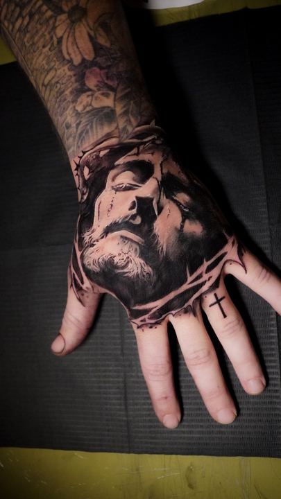 Black and grey realism portrait tattoo on the back of a hand
