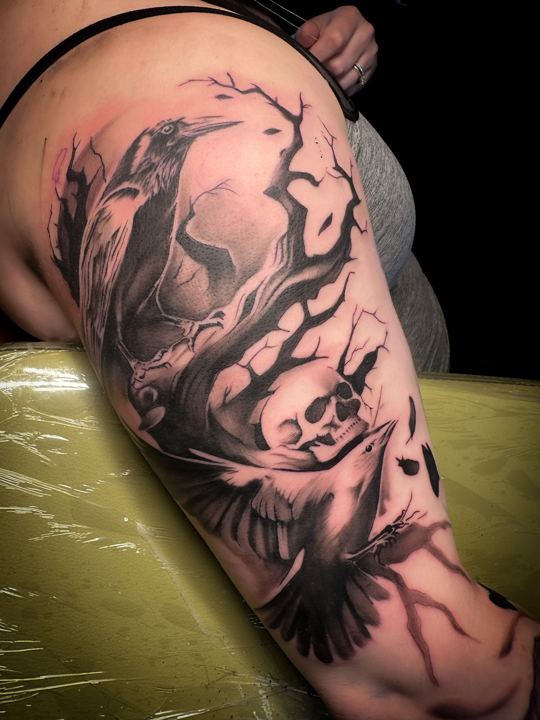 Black and grey realism raven, tree and skull tattoo on a shoulder