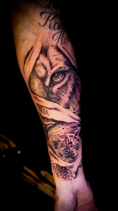 Black and grey realism lion and cub tattoo on a forearm