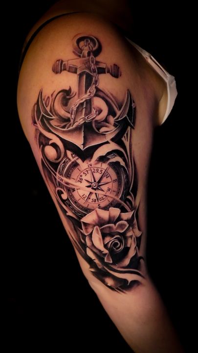 Black and grey realism anchor, compass and rose tattoo on an upper arm